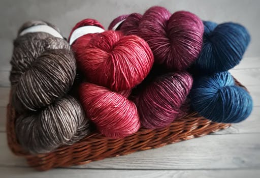 A variety of colorful yarn skeins arranged neatly in a woven basket, perfect for crafting.